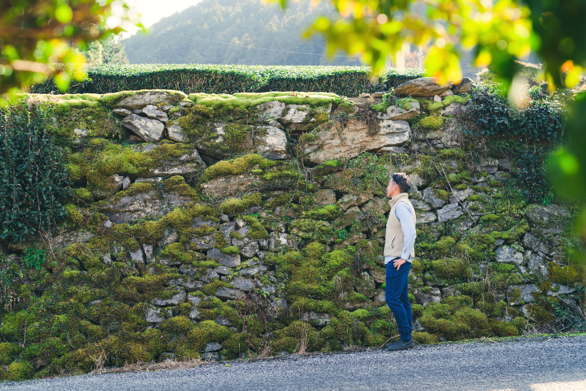 歴史が積み重ねられた石垣をみる松永浩二
